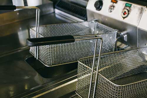 Commercial kitchen grease trap and metal baskets for efficient waste management in plumbing systems.