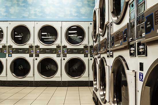 Laundromat interior showcasing multiple commercial washing machines, emphasizing the importance of reliable plumbing systems for businesses.